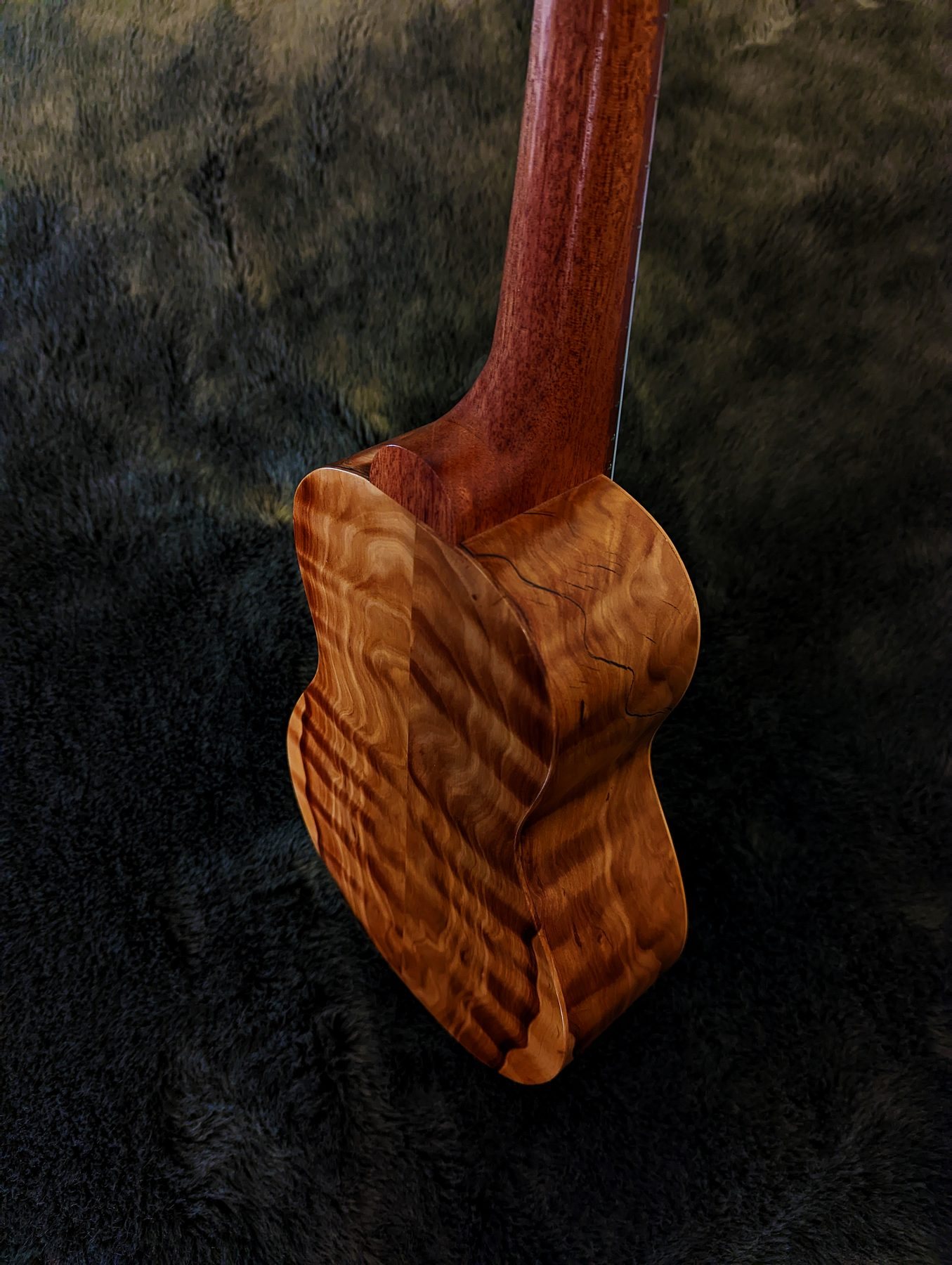The neck heel and shoulder of the ukulele showing wrapping Callitris figure